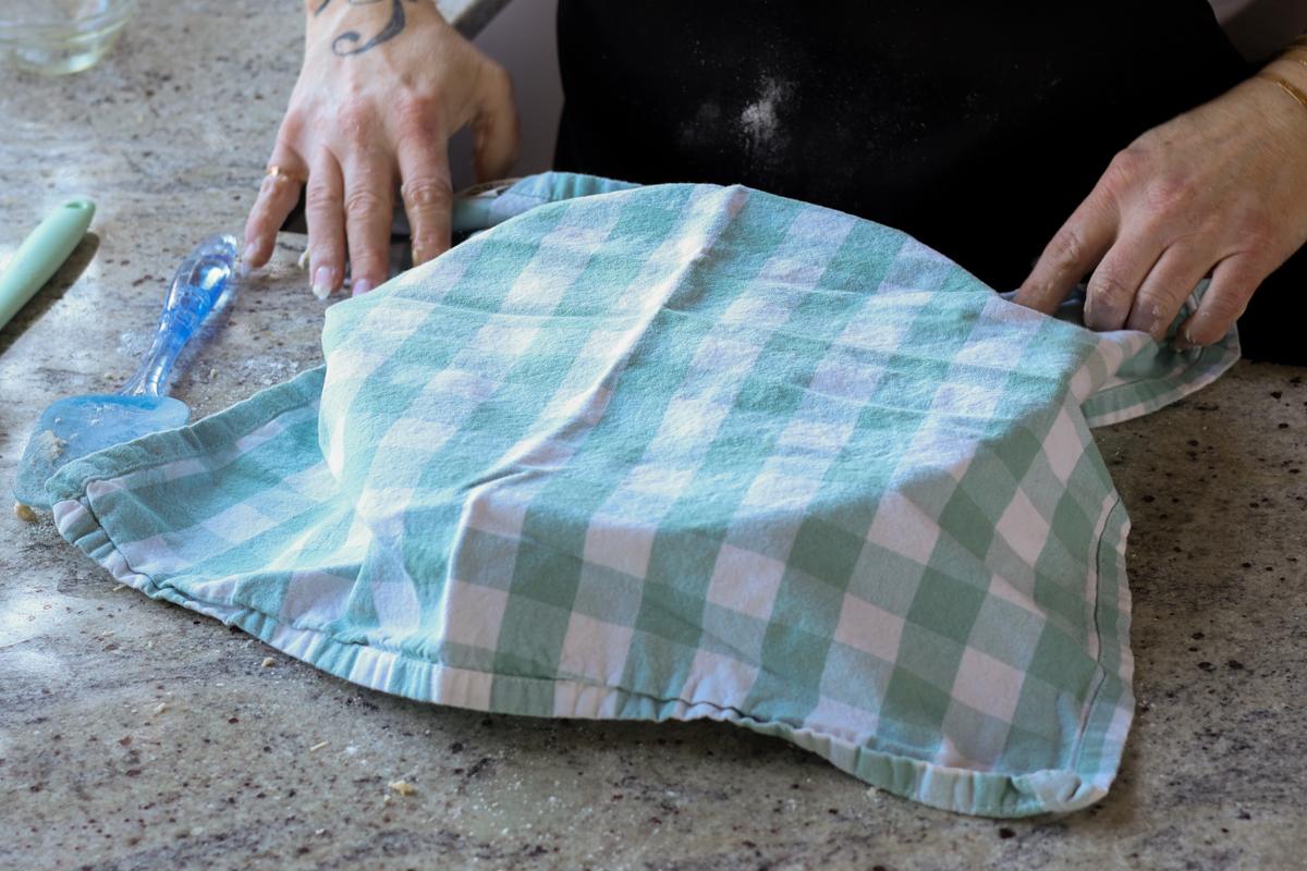 covering the bowl of dough with a kitchen towel
