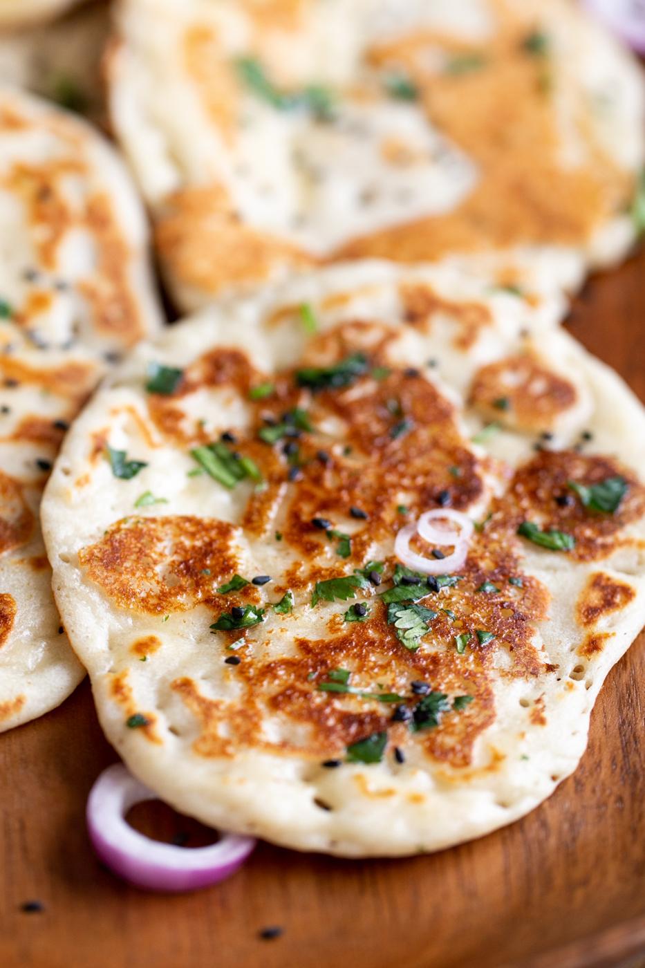 side shot of a piece of naan bread on a wooden board