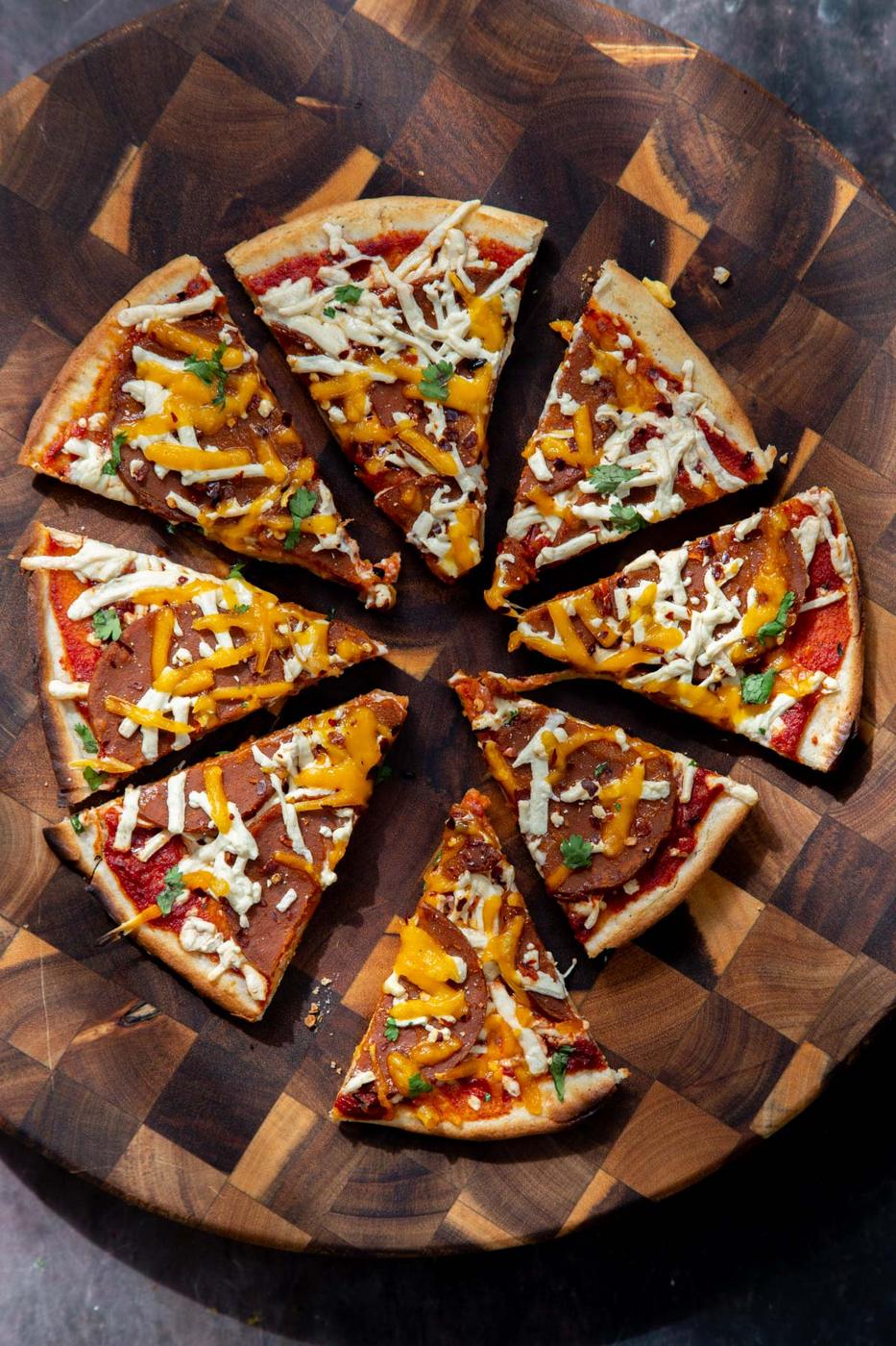 sliced vegan pepperoni and cheese pizza with almond flour crust
