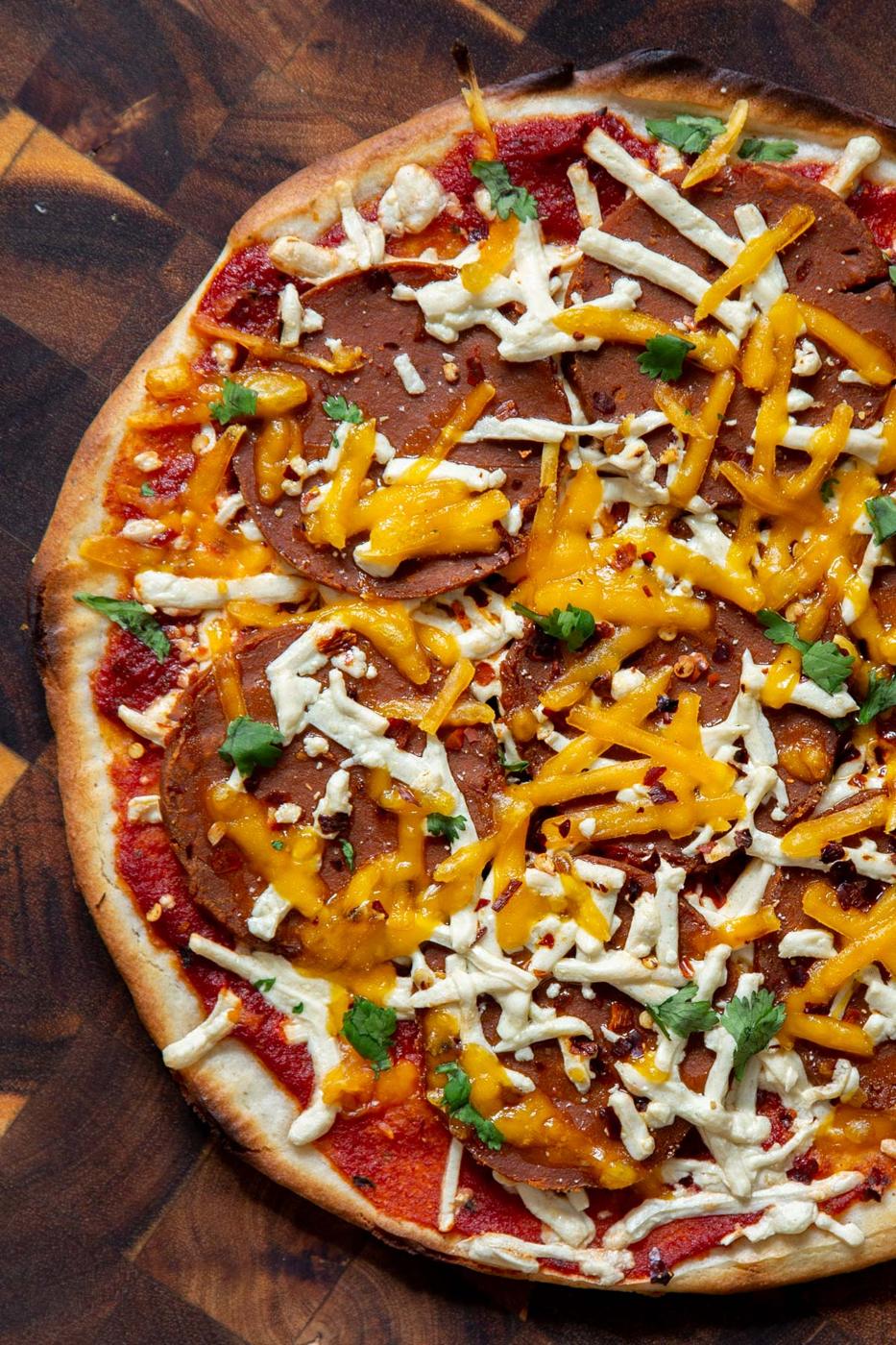 overhead shot of a vegan pizza made with almond flour crust and topped with pepperoni and cheese