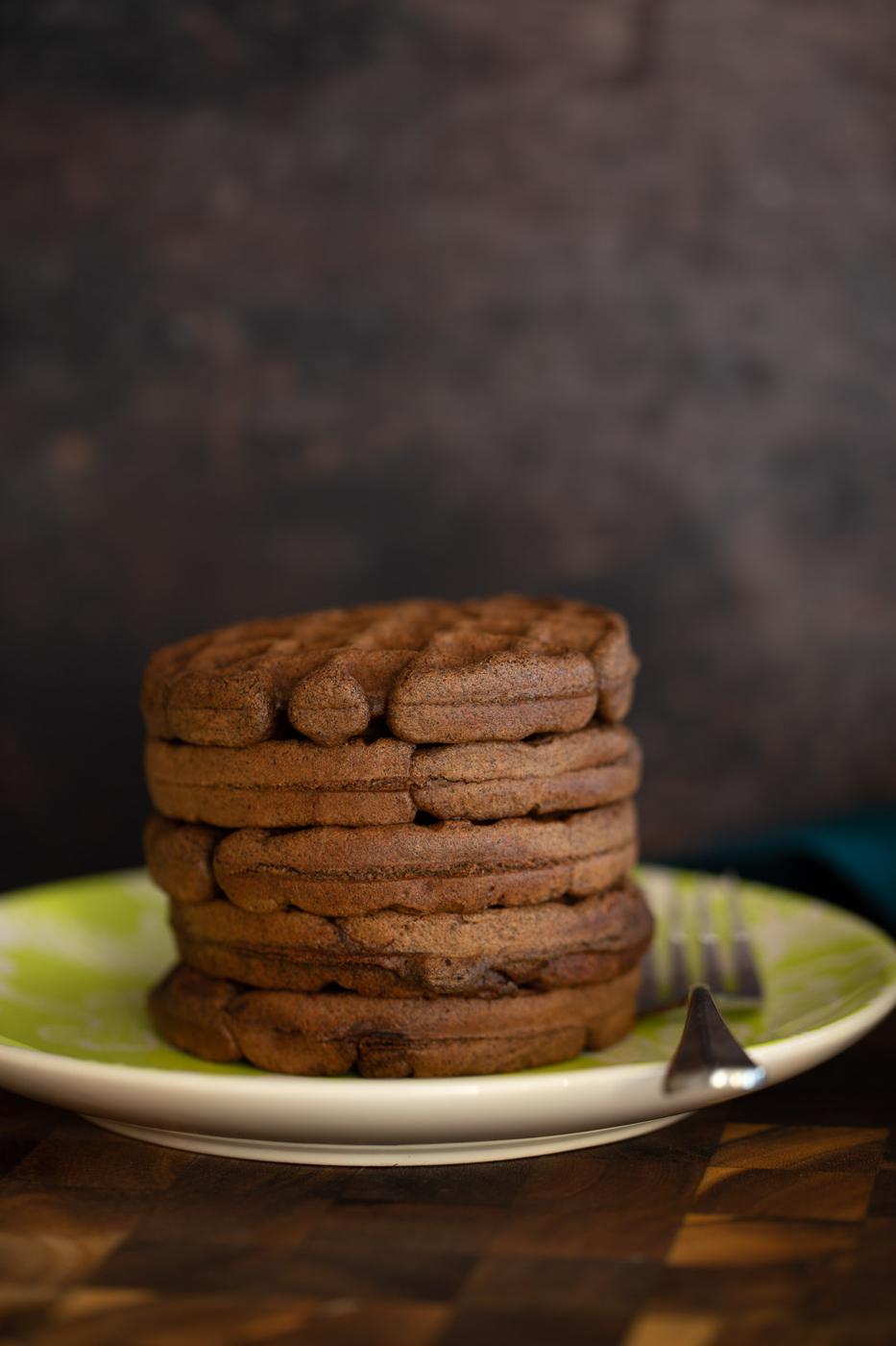 a stack of buckwheat oat flour waffles on a green plate