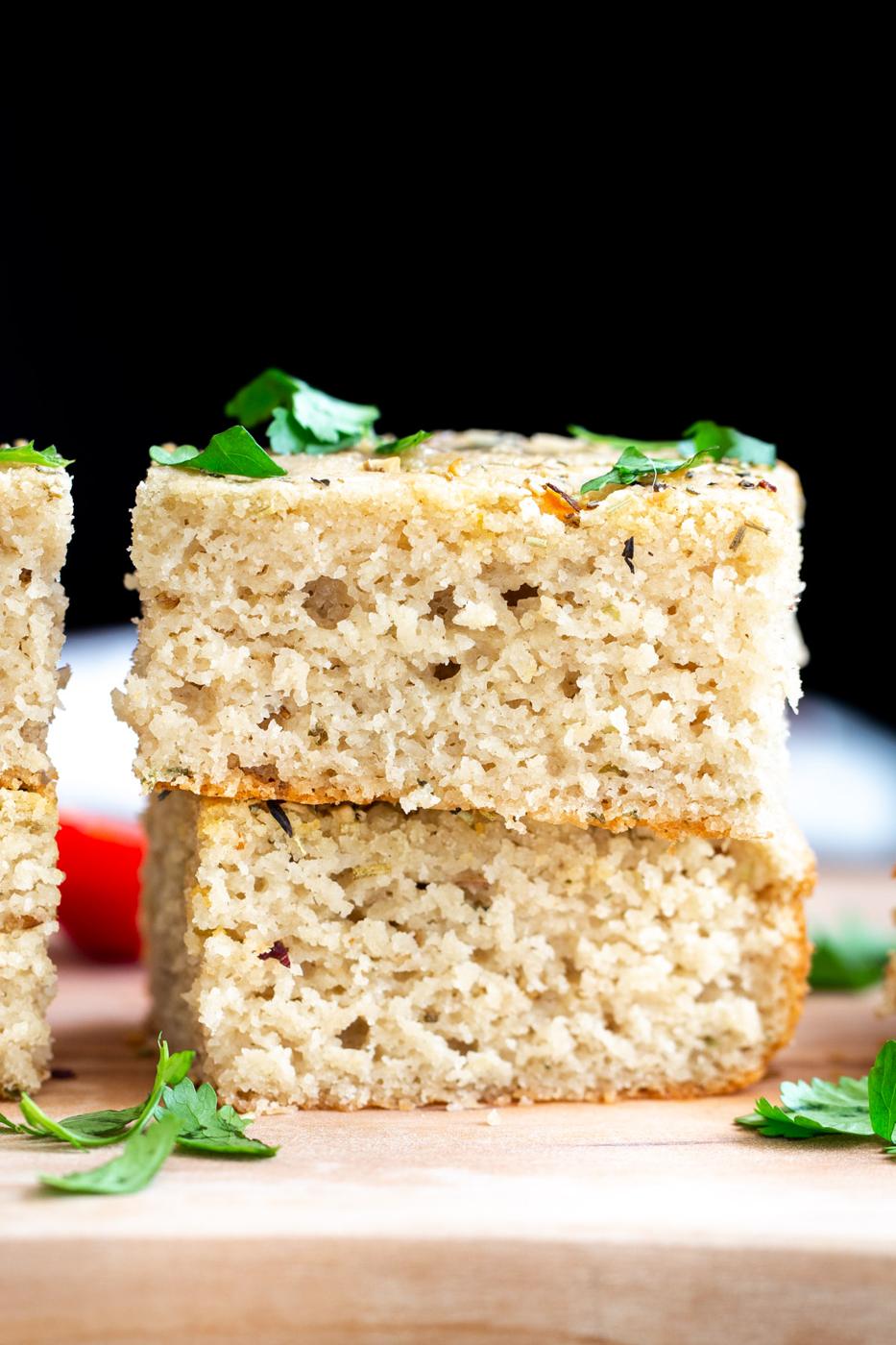 stacked slices of vegan glutenfree focaccia bread on a wooden board