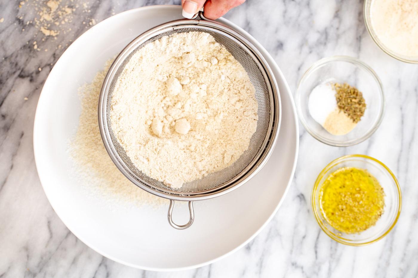 dry bread ingredients being sifted into a bowl