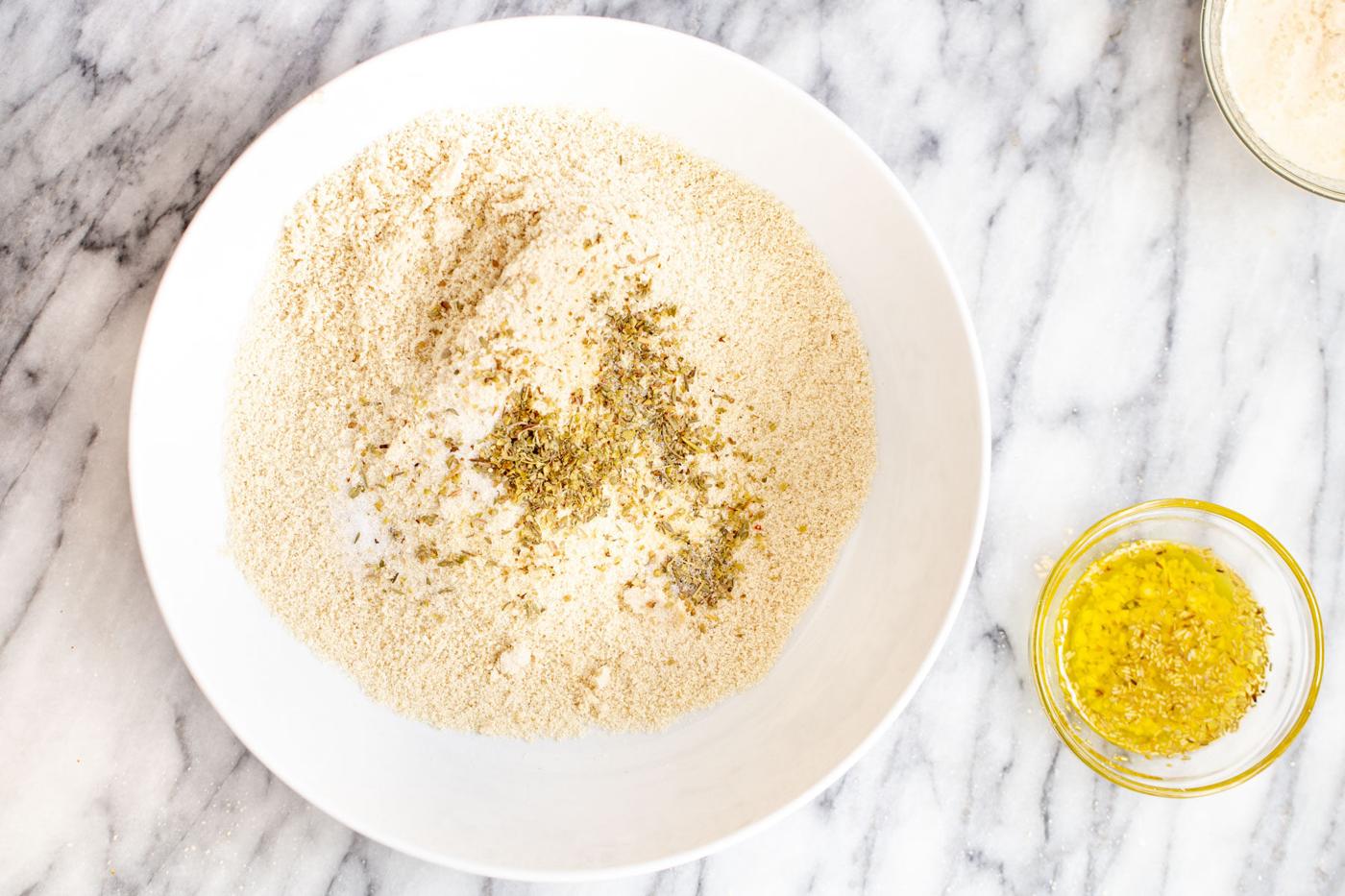 glutenfree flour mix with added herbs next to a small dish with olive oil