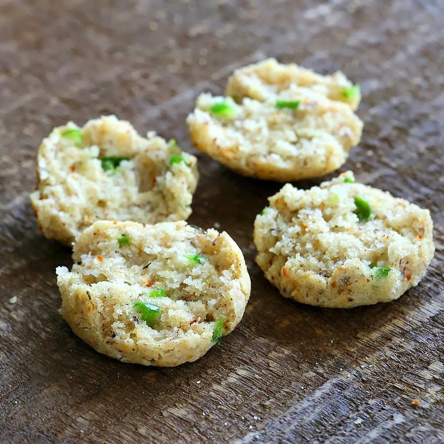 two small gluten-free cheese biscuits cut into halves to reveal specks of jalapeno pepper