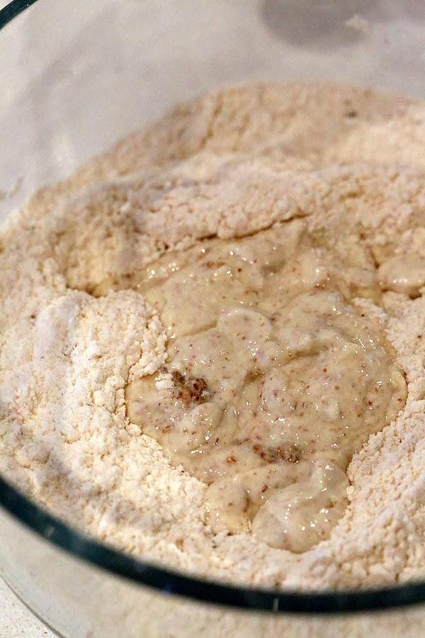 wet ingredients being added to dry ingredients in a glass bowl to make gluten free biscuits recipe
