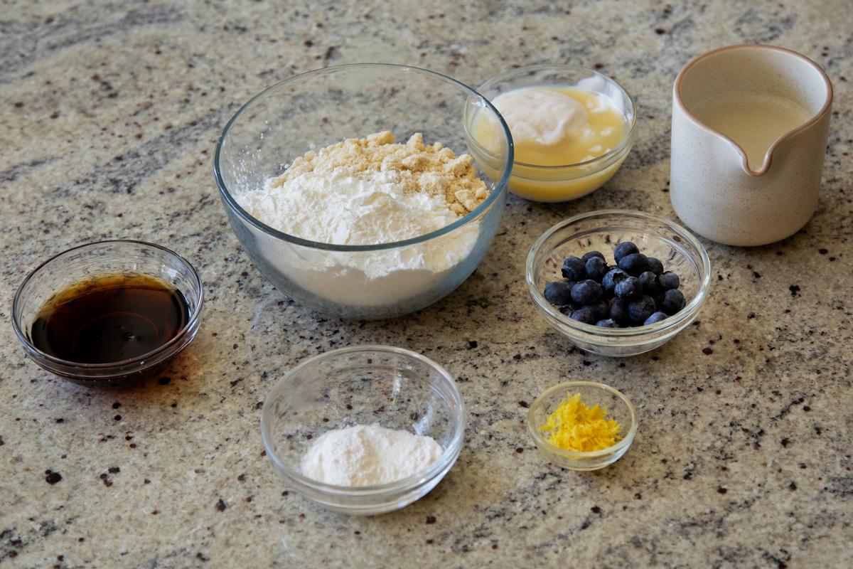 almond flour, tapioca starch, blueberries, lemon zest, and other pancake ingredients in bowls on the kitchen counter