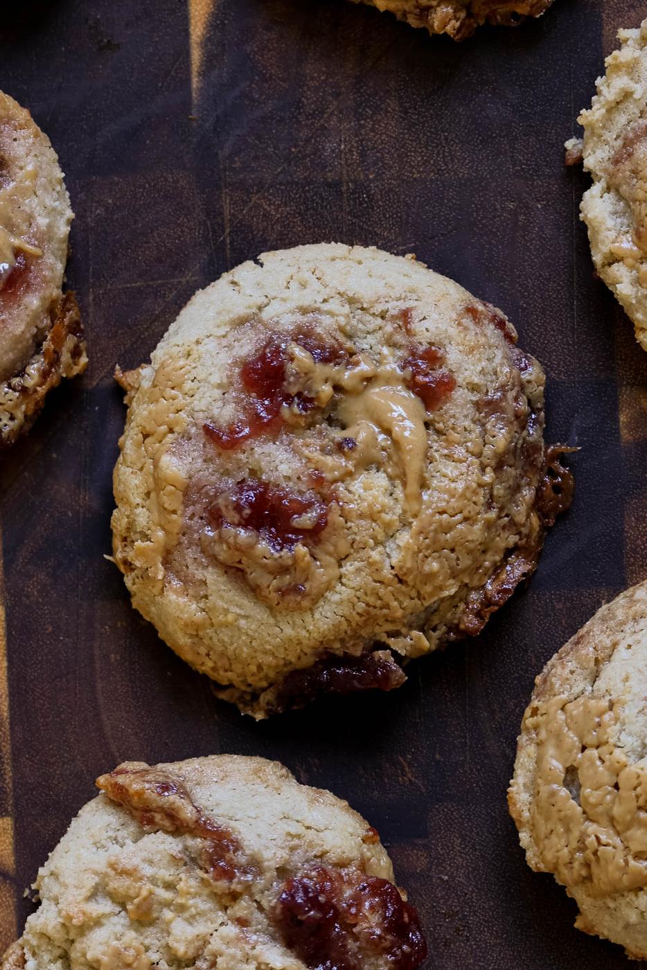 close-up of gluten-free peanut butter and jelly cookies on a wooden cutting board
