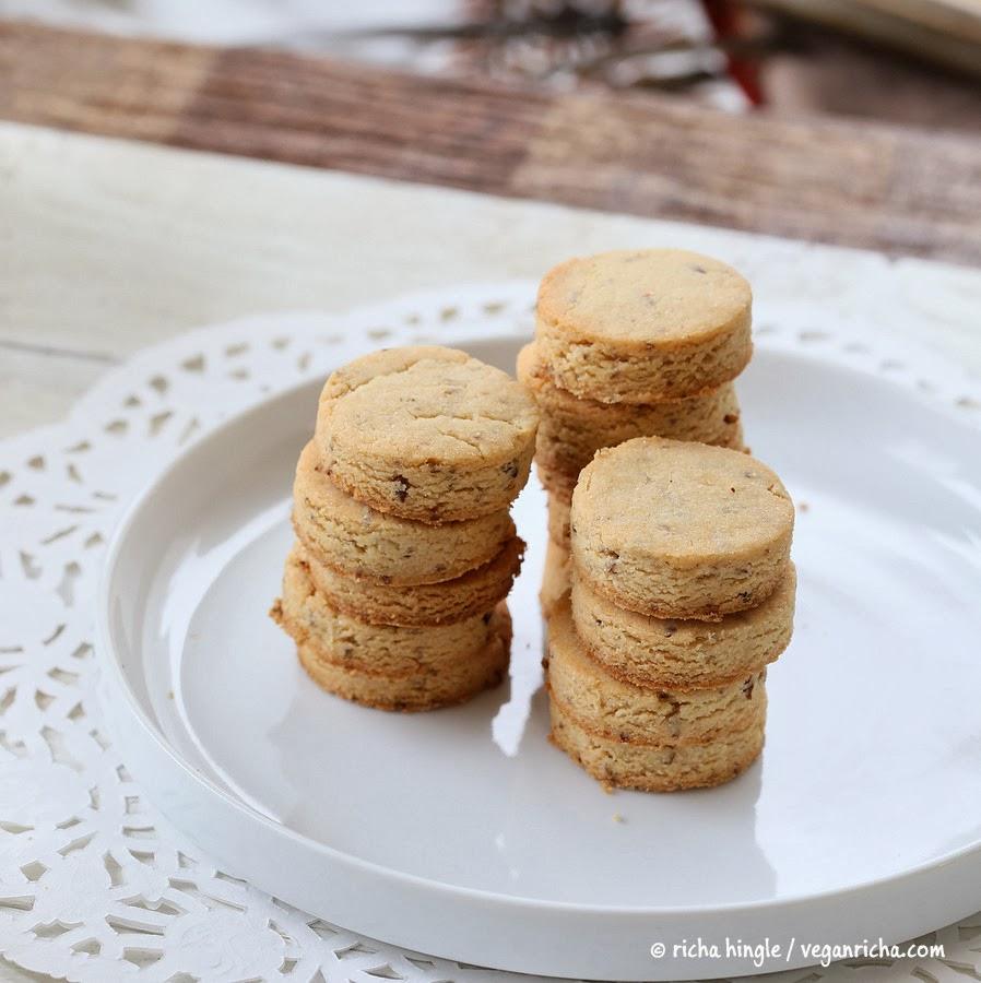 vegan sugar cookies stacked on a white cookie platter