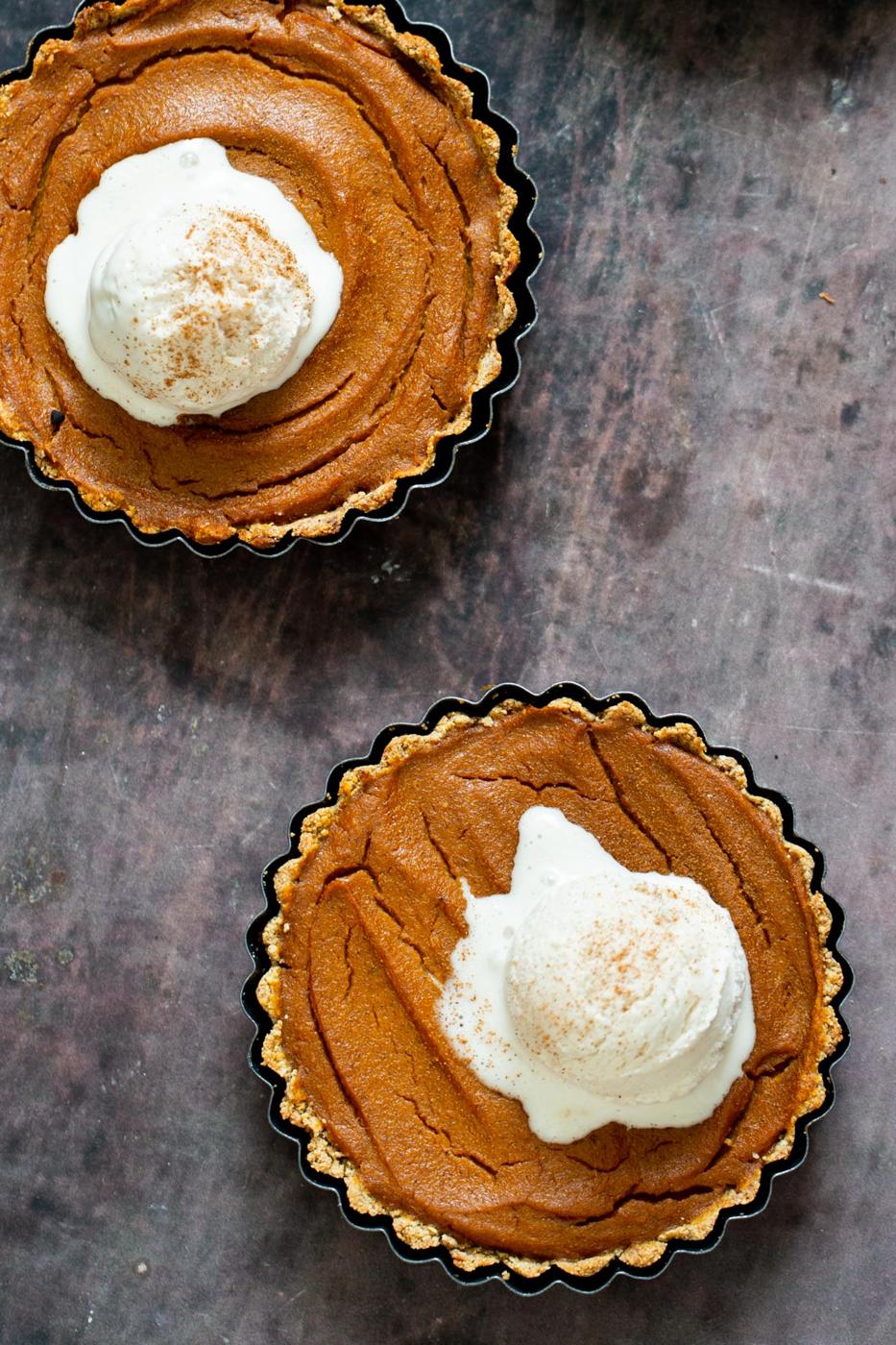 two gluten free vegan pumpkin pies topped with vanilla ice cream