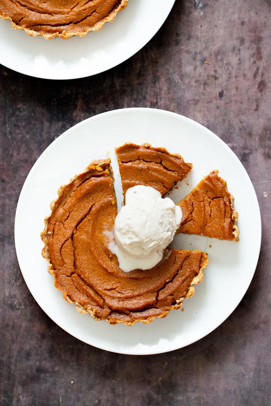 individual gluten free vegan pumpkin pie on a plate with two mini slices cut