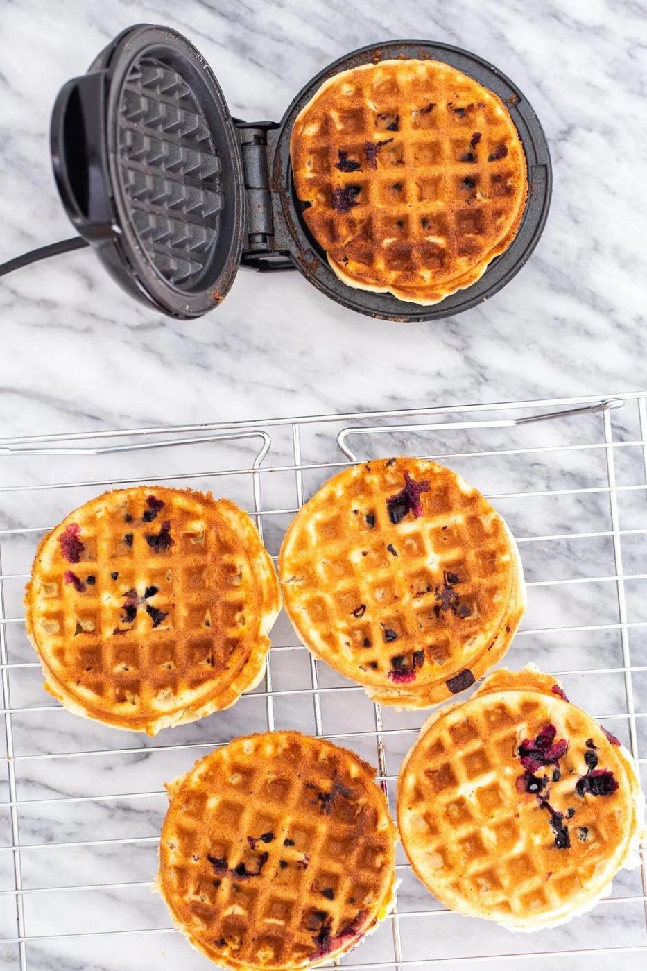 freshly baked glutenfree lemon blueberry waffles cooling on a cooling rack