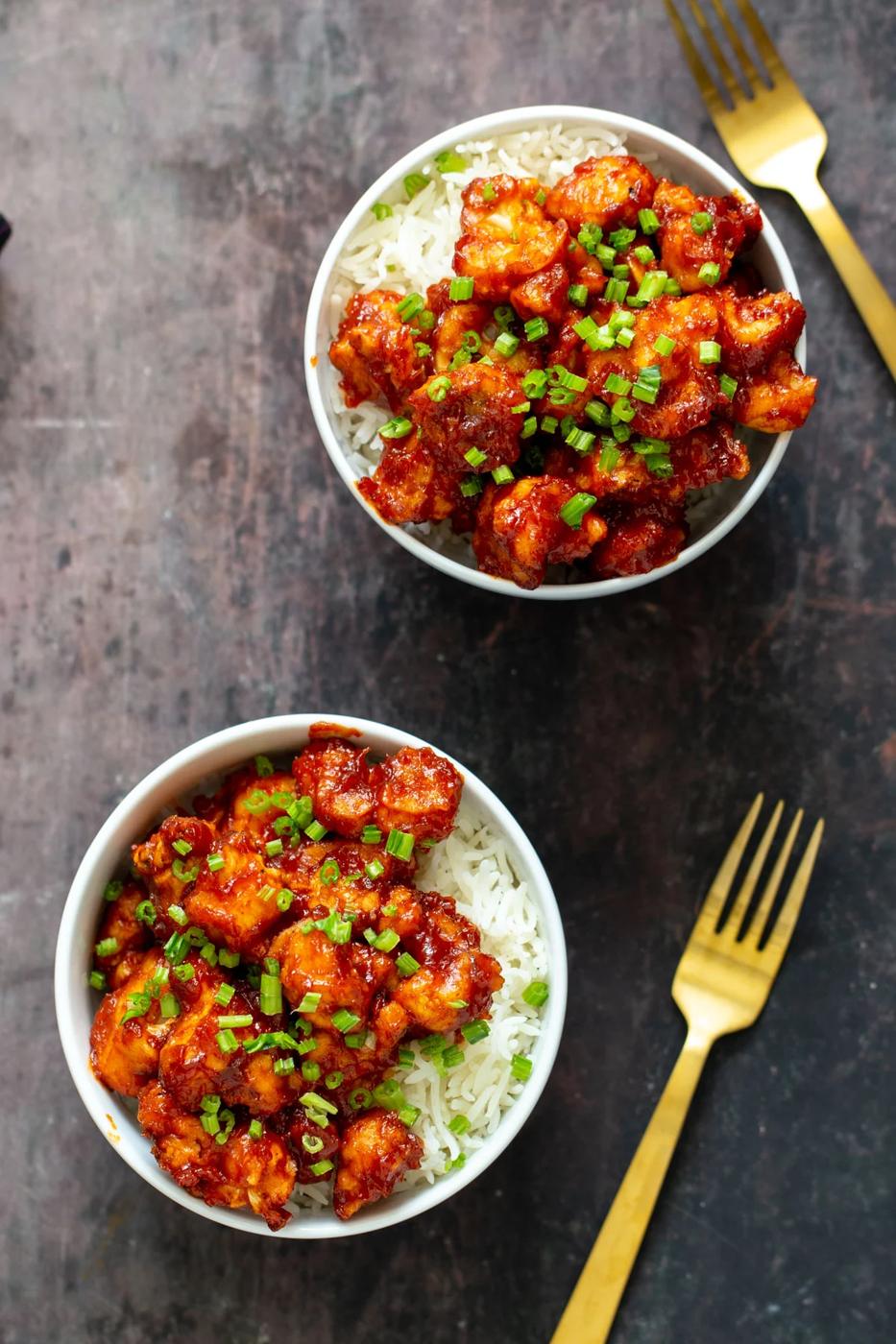 gochujang cauliflower wings in bowls with rice and green onions