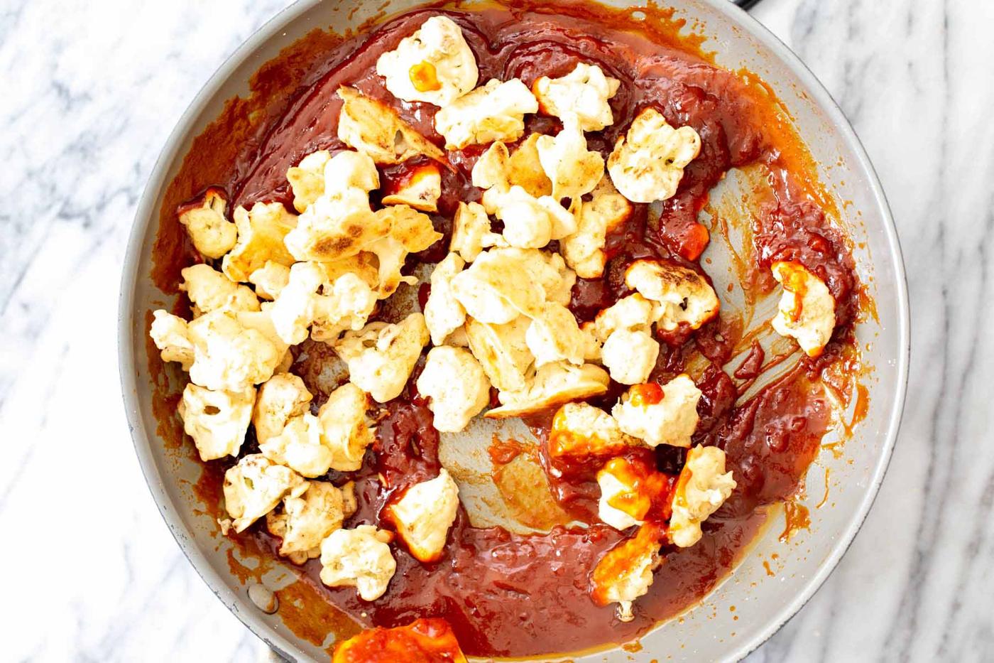 adding cauliflower to the pan of gochujang sauce
