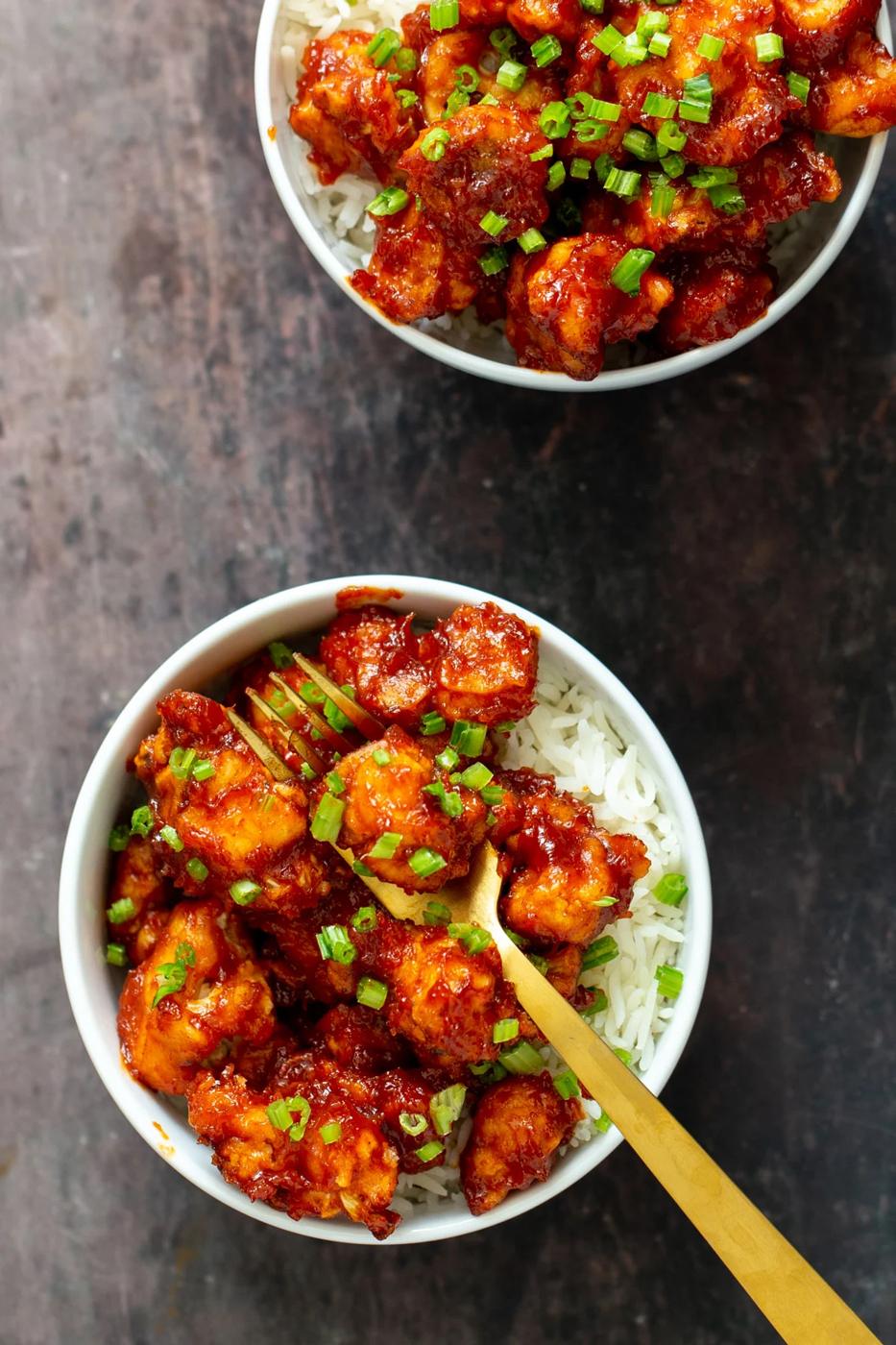gochujang cauliflower wings in bowls with rice and green onions