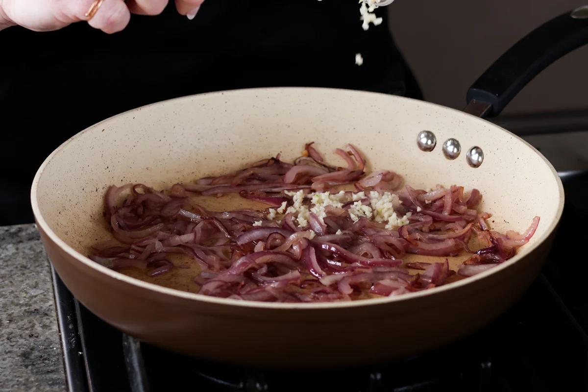 adding the garlic to the partially cooked onions