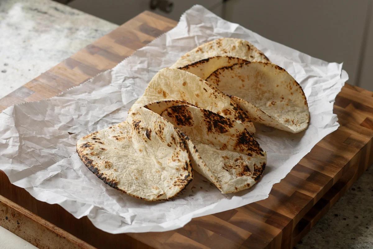 warmed tortillas on a cutting board