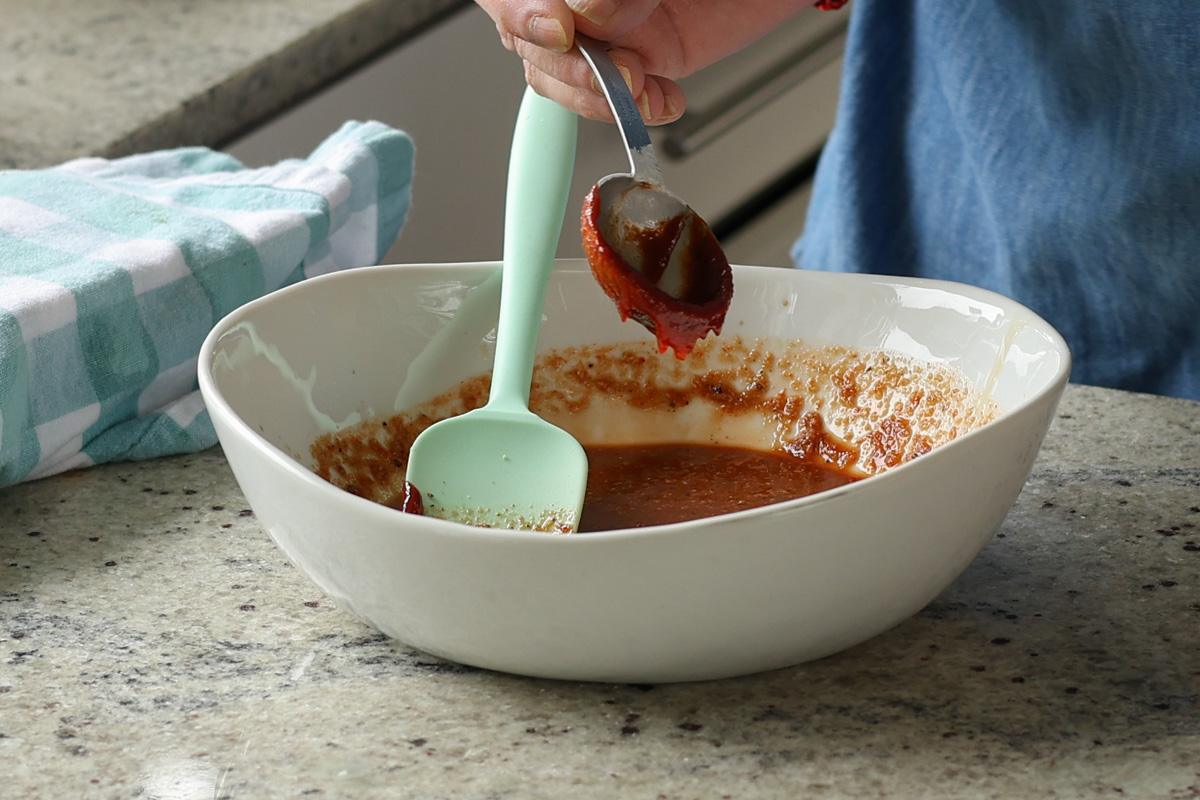 adding gochujang tofu marinade ingredients to a bowl