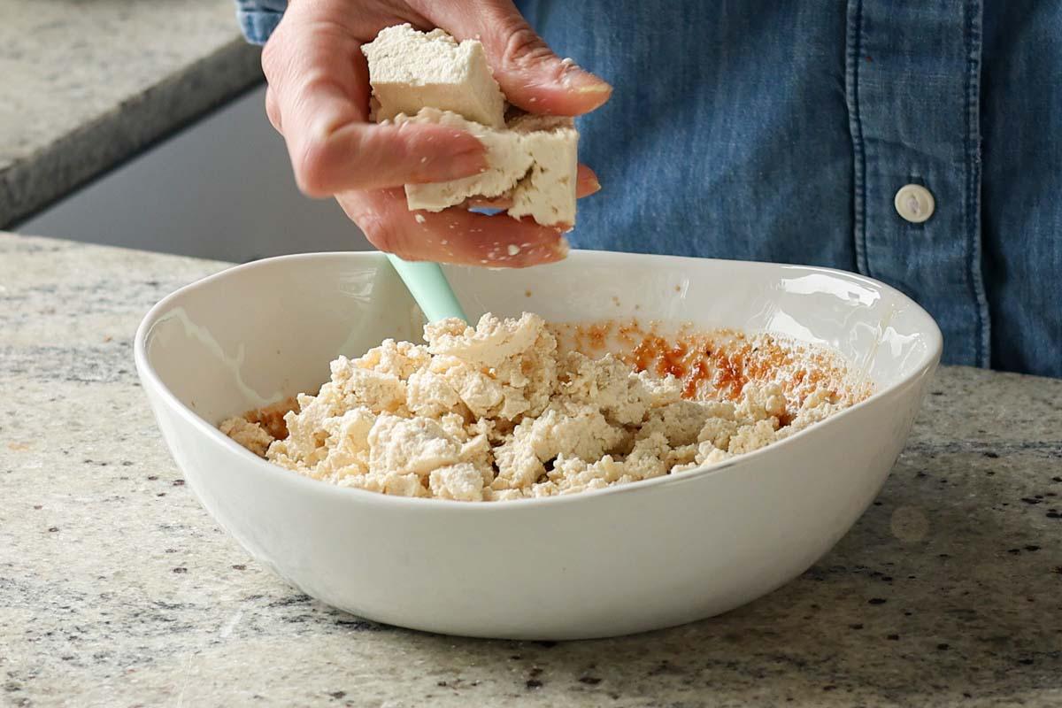crumbling tofu into the bowl