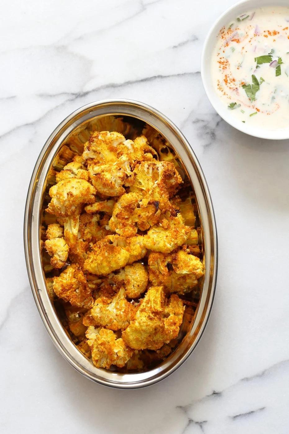 Turmeric Roasted Cauliflower with Raita Dip. These Delicious Golden Cauliflower Bites are easy and quick. Serve with a dash of lemon or with a Yogurt onion dip or Green Chutney. #Vegan #Soyfree #Nutfree #veganricha #Recipe. Can be #glutenfree