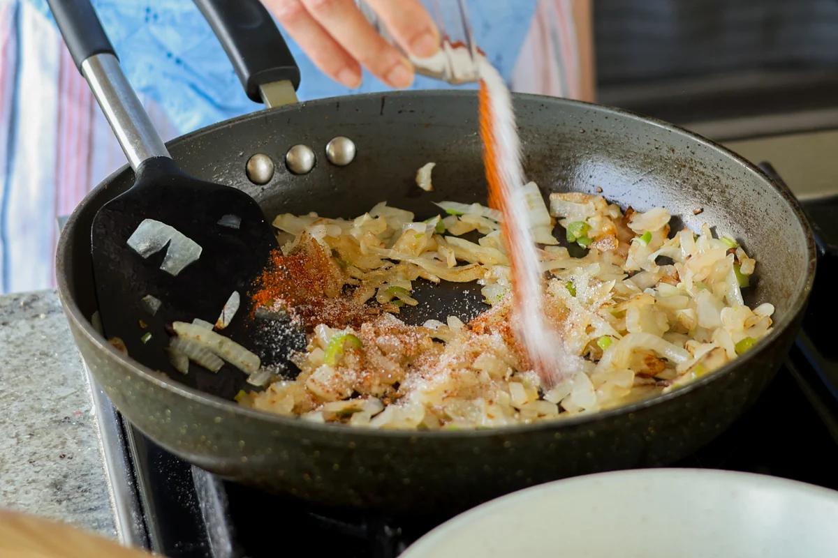 Spices added to the skillet with the onion.