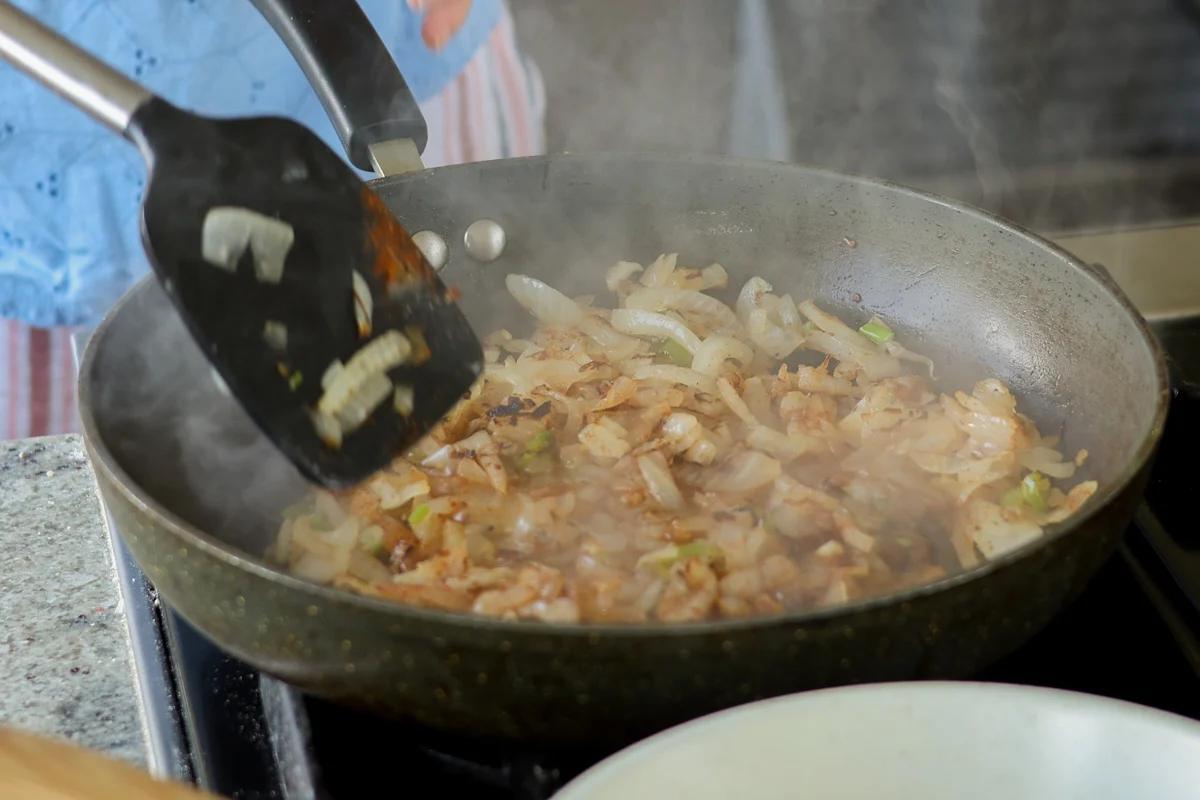 Onions and green chili cooking in a skillet.