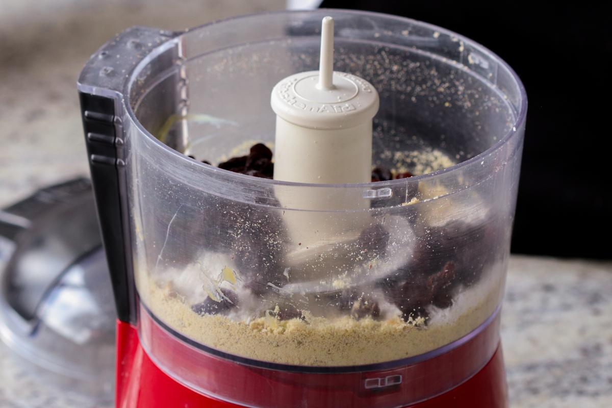 adding raisins and coconut to the food processor