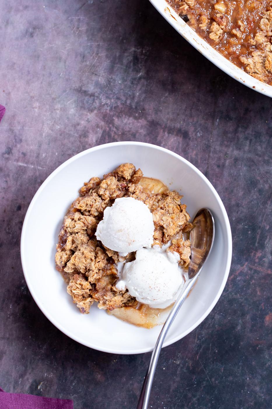 a bowl of apple pear crisp with two scoops of ice cream