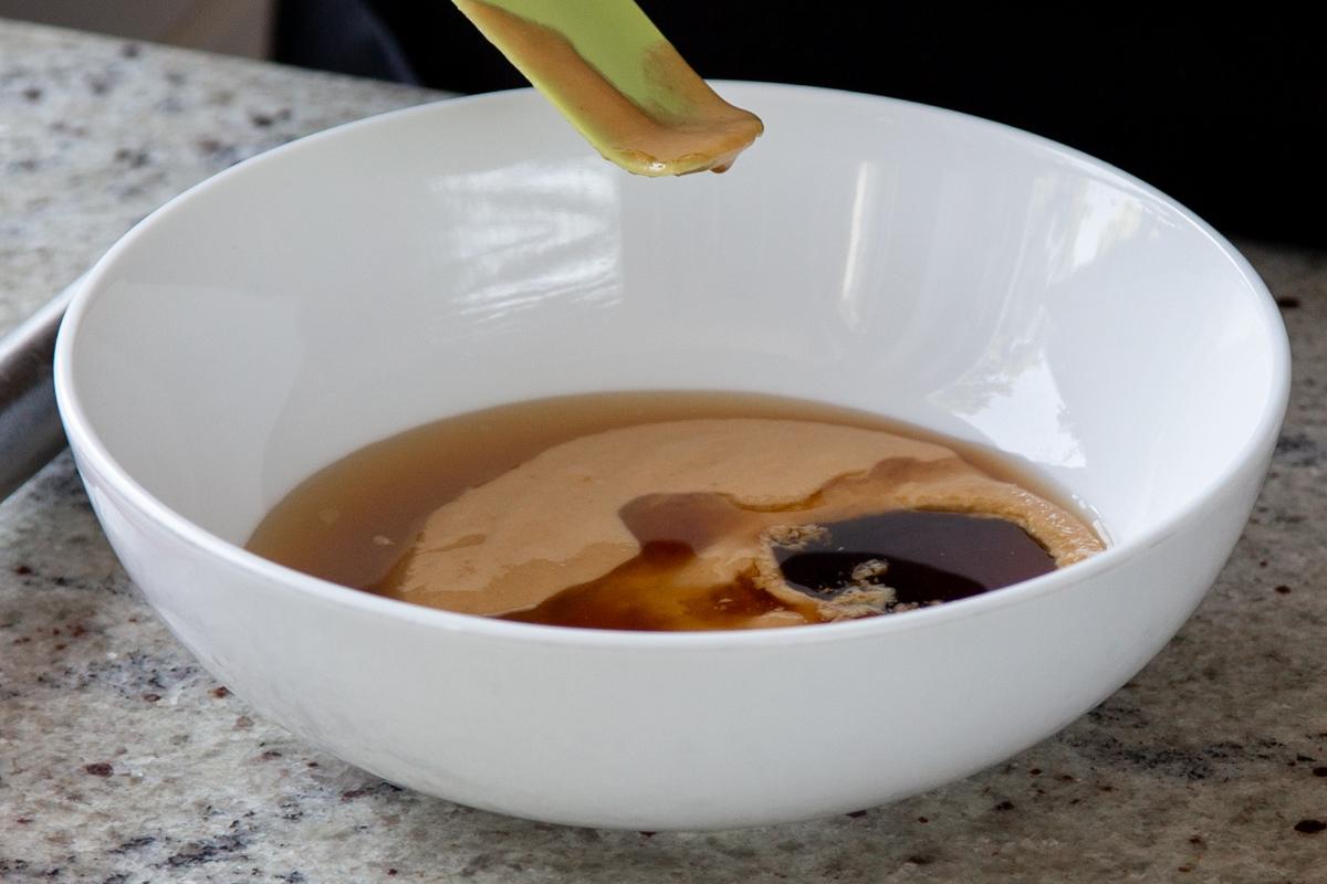 adding other tahini sauce ingredients to the bowl with the tahini