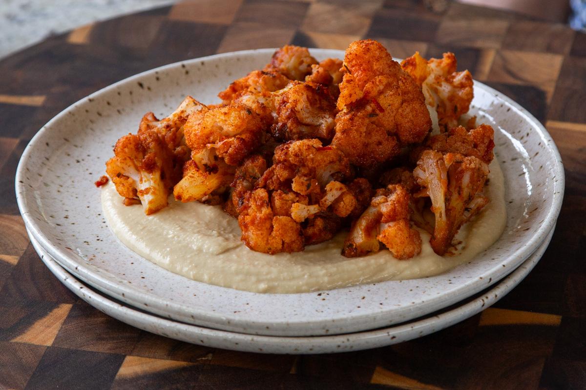 harissa cauliflower on a plate with hummus