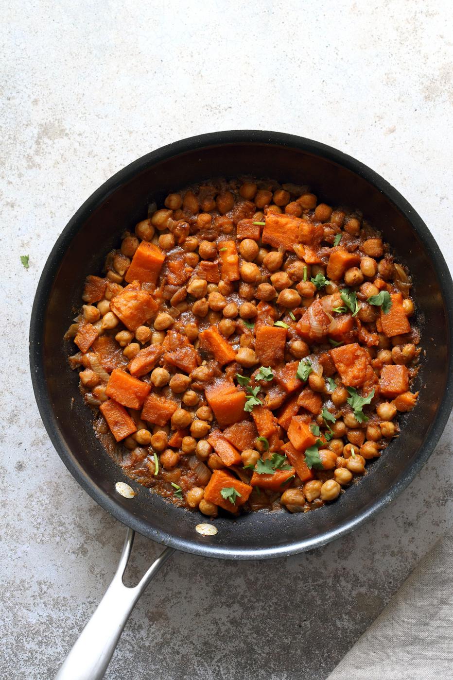 Our Harrisa Chickpea Stew in Black Skillet over Concrete