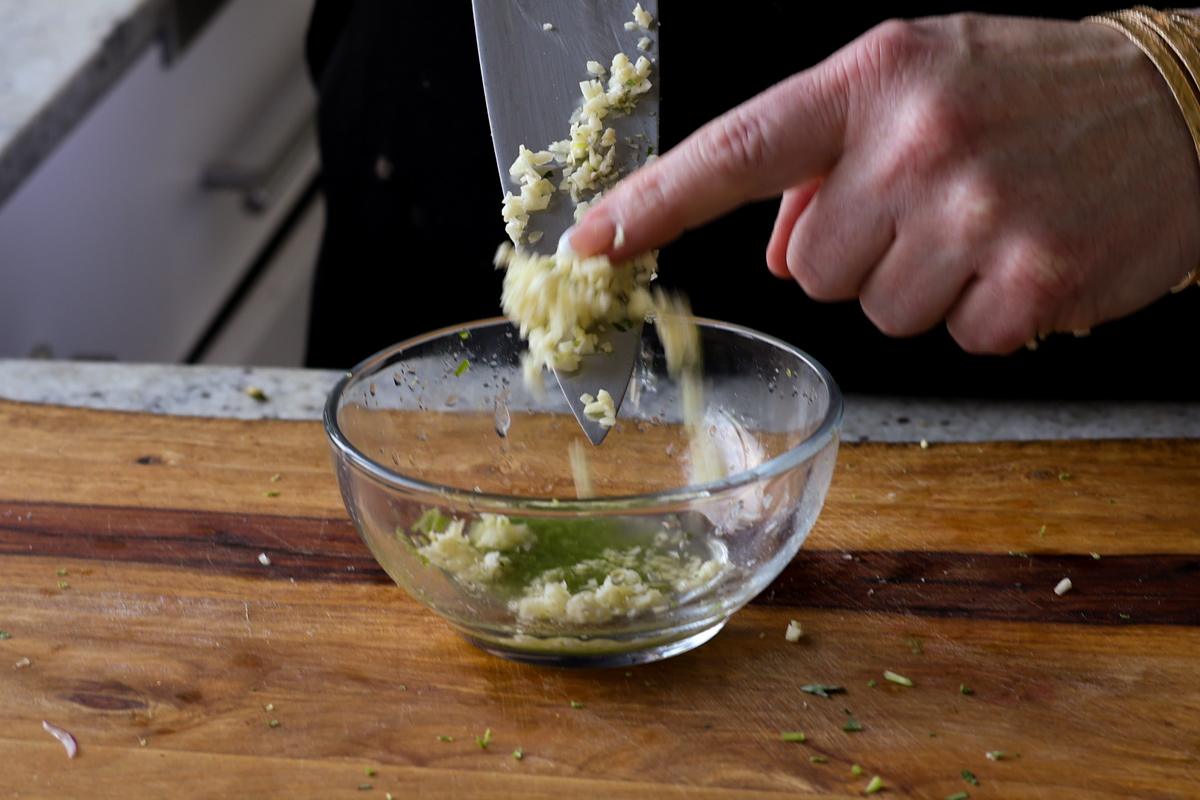 adding minced garlic to the bowl
