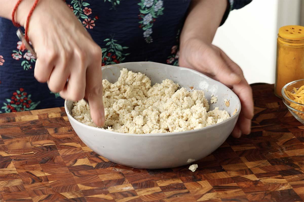 mashing the tofu in the bowl
