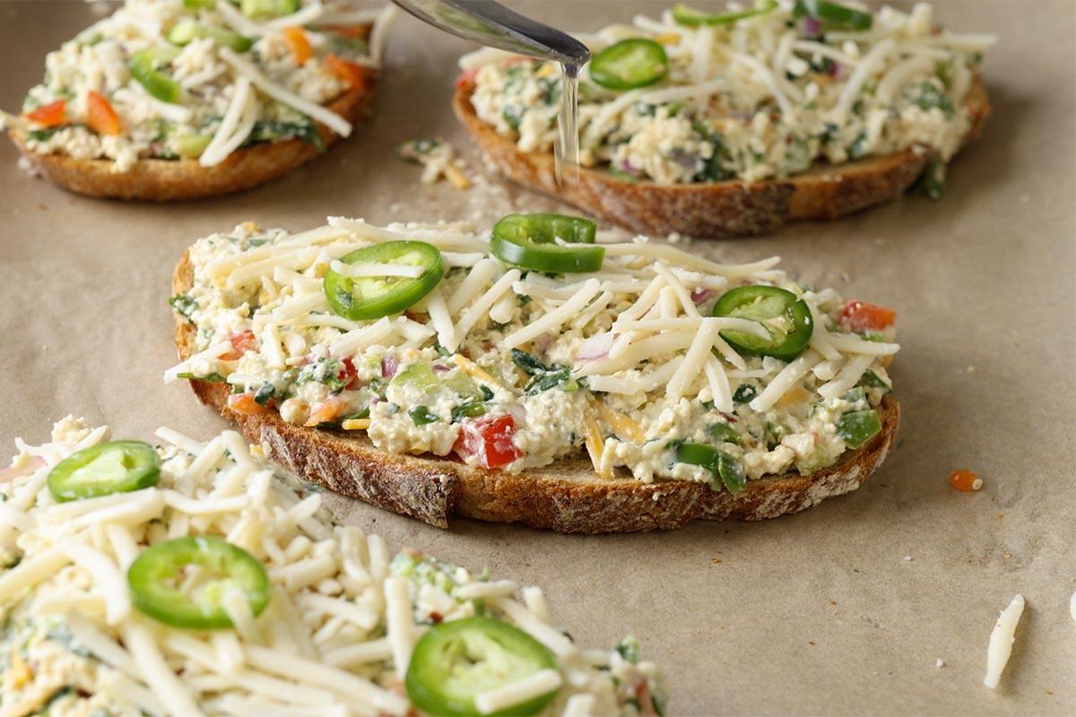 chilli cheese toasts topped with cheese shreds and sliced green chillies