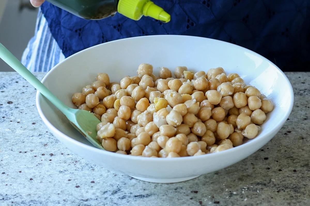 adding cooked chickpeas to the bowl