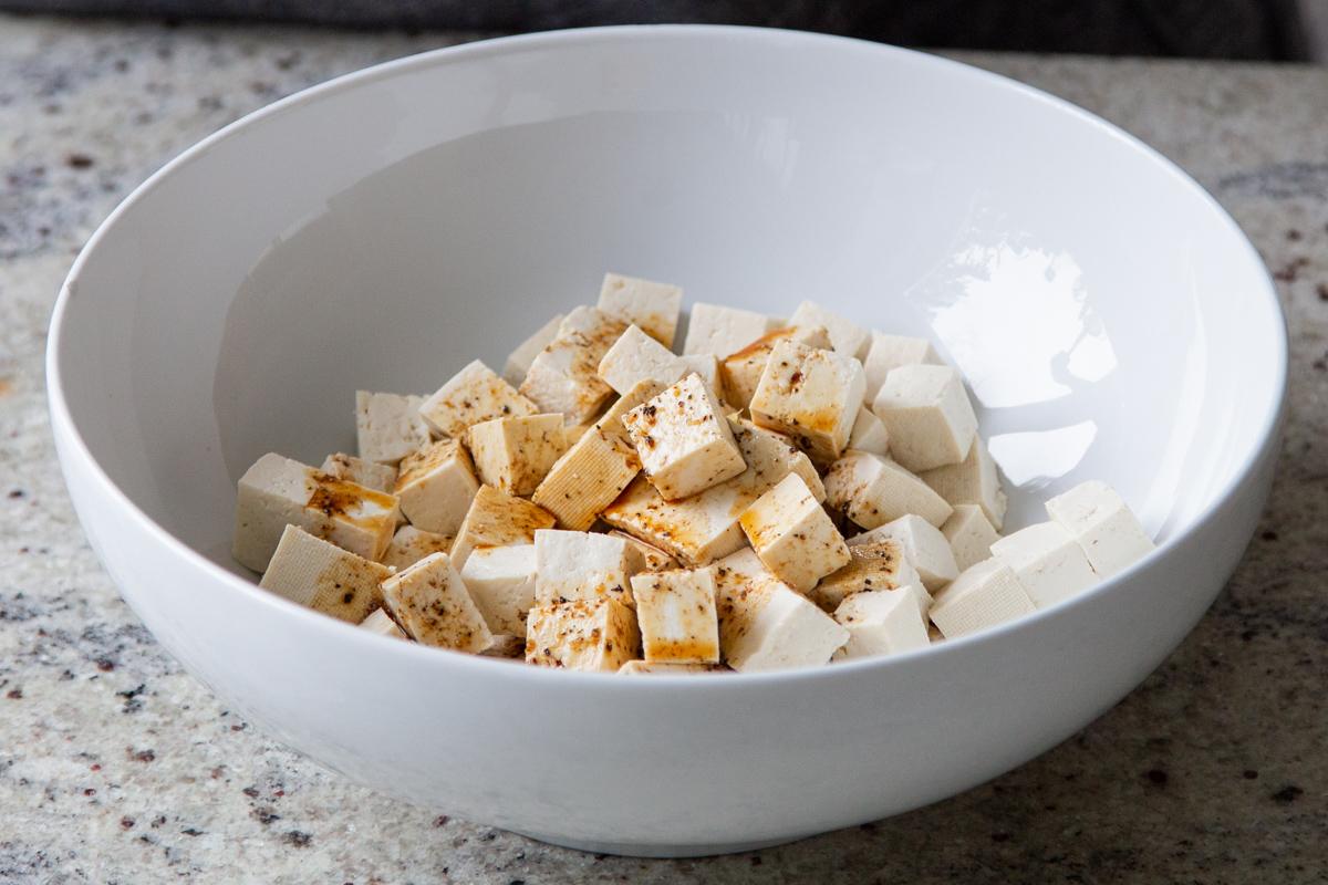 tofu in the bowl with soy sauce, before tossing