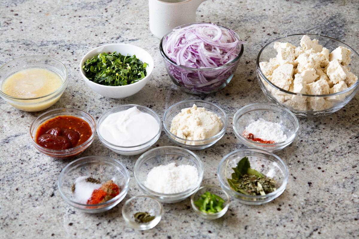 almond flour, onion, cilantro, and other curry ingredients in bowls on the kitchen counter