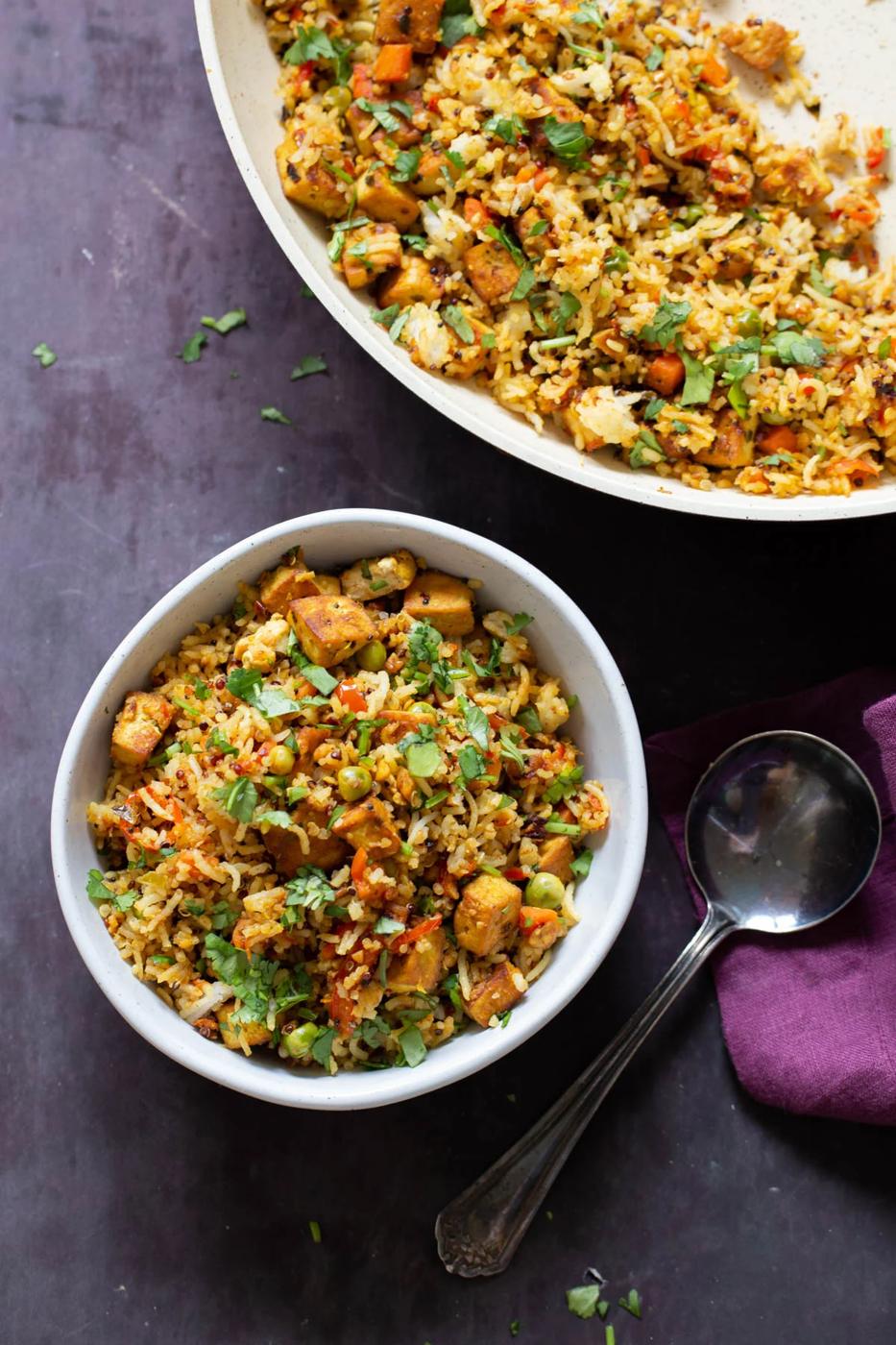 bowl of podi rice next to the pan of cooked tofu rice stir fry