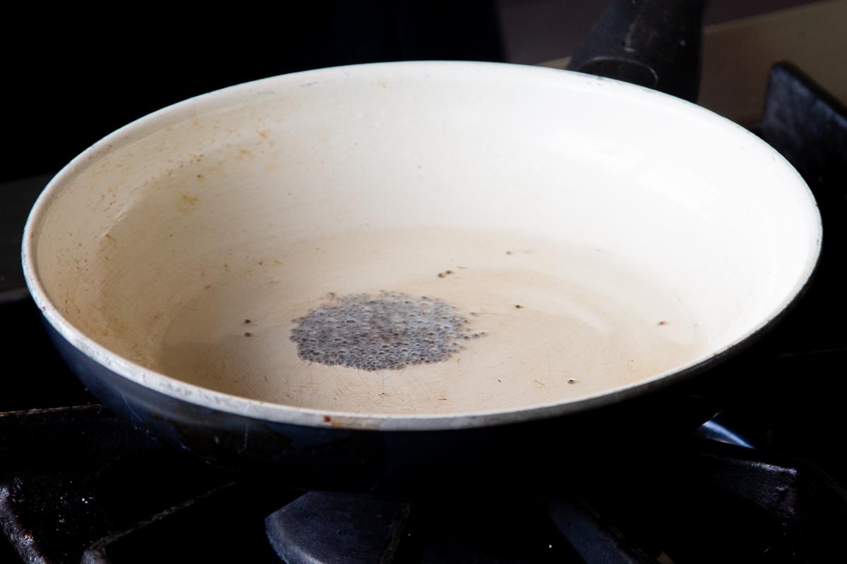 toasting the mustard seeds in a hot pan of oil