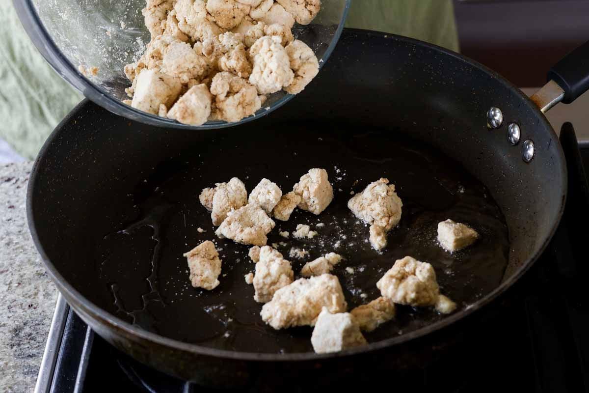 adding tofu to the pan