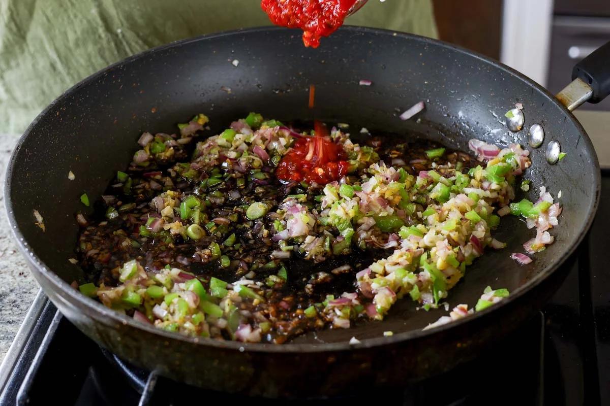 adding sambal oelek to the pan