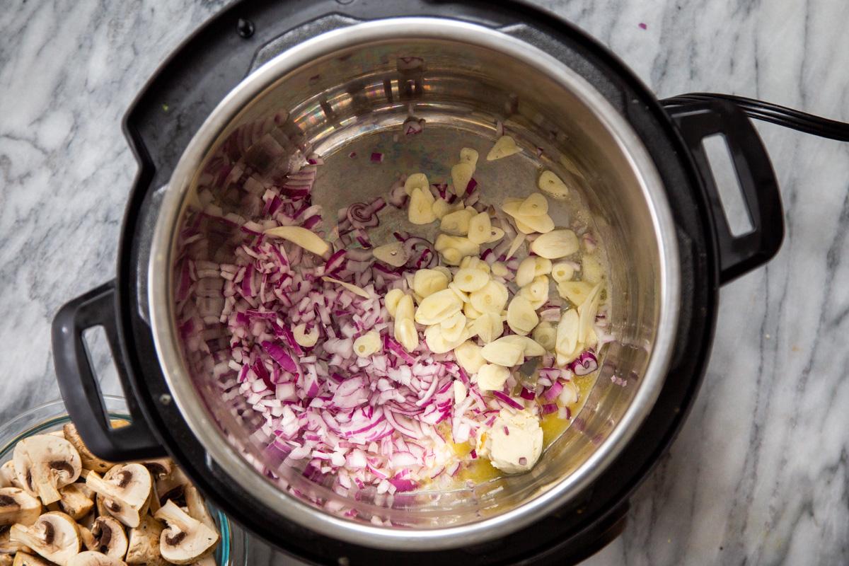 chopped red onion and sliced garlic in an Instant Pot