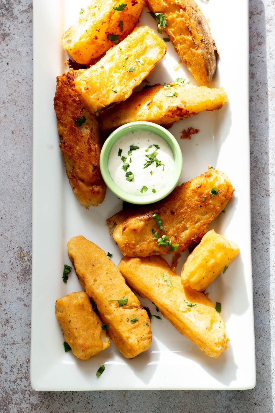vegan homemade baked jo jo potatoes served with a dip on a white platter
