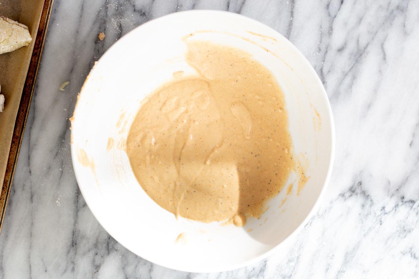 batter for making jo jo potatoes in a white bowl