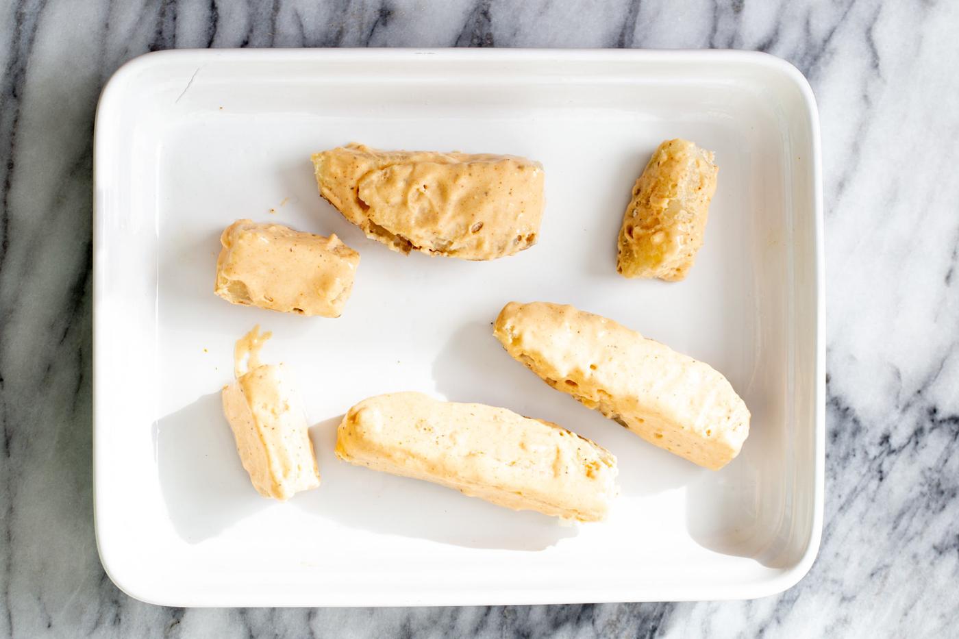 breaded potato wedges in a white casserole dish