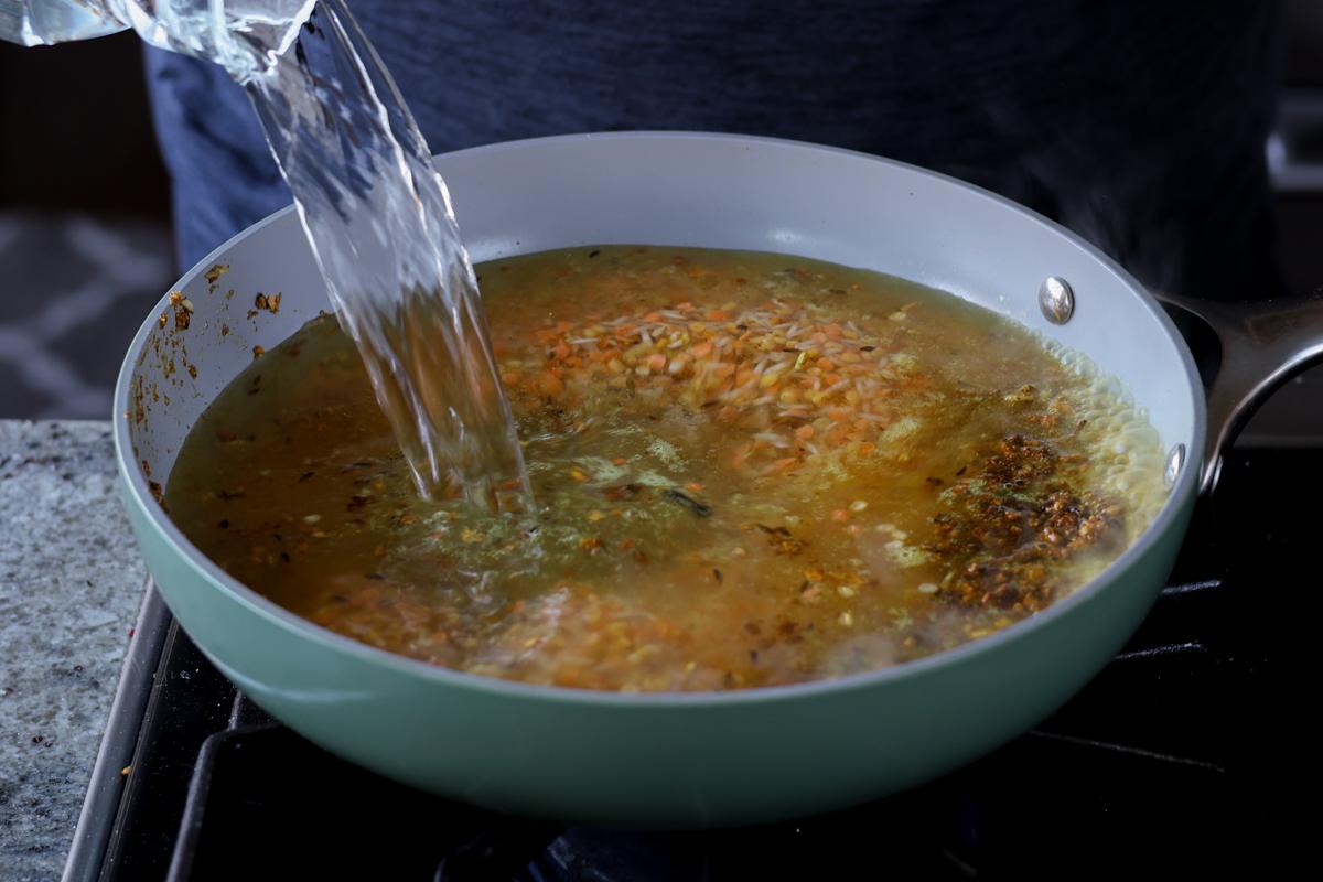 adding water to the lentils and rice