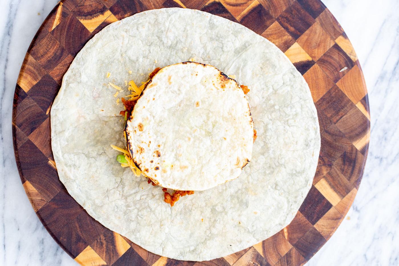a tostada being placed on toppings