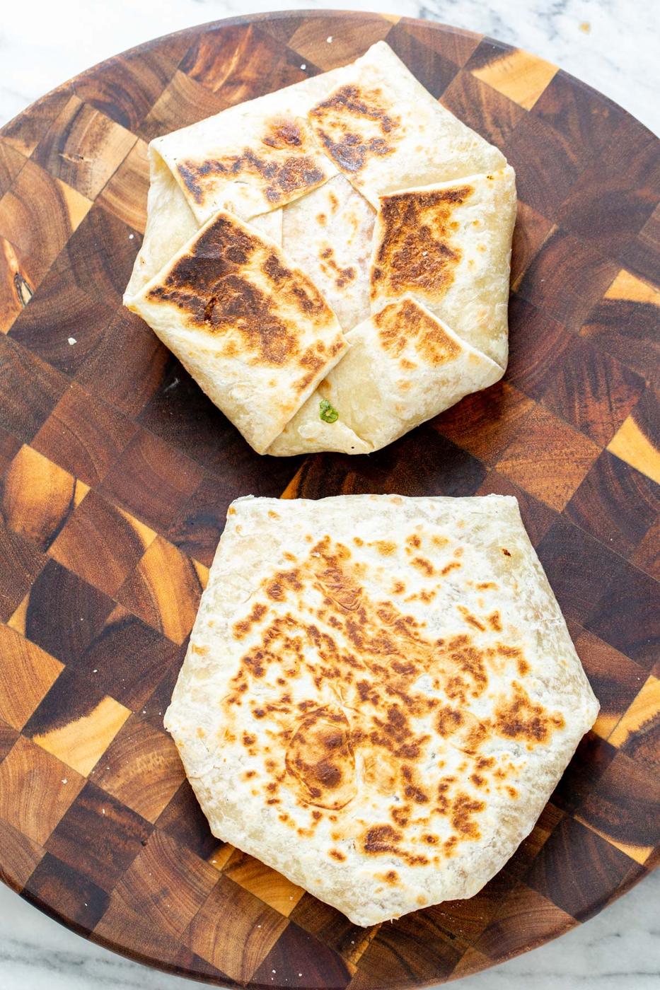 two vegan crunchwraps placed on a wooden board