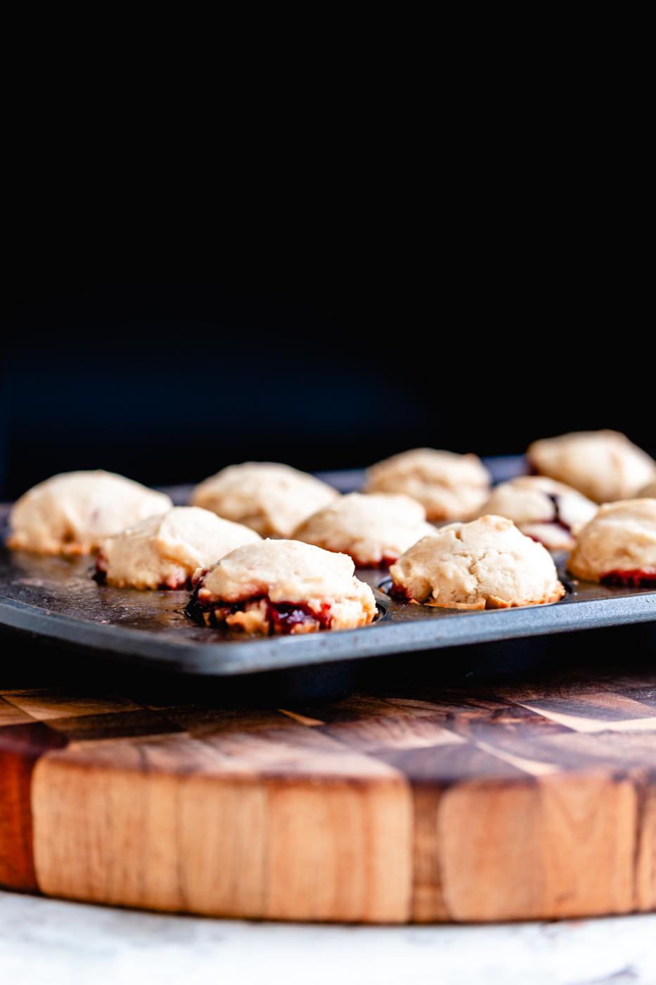 side view of vegan jam filled baked donut holes cooling in a muffin pan