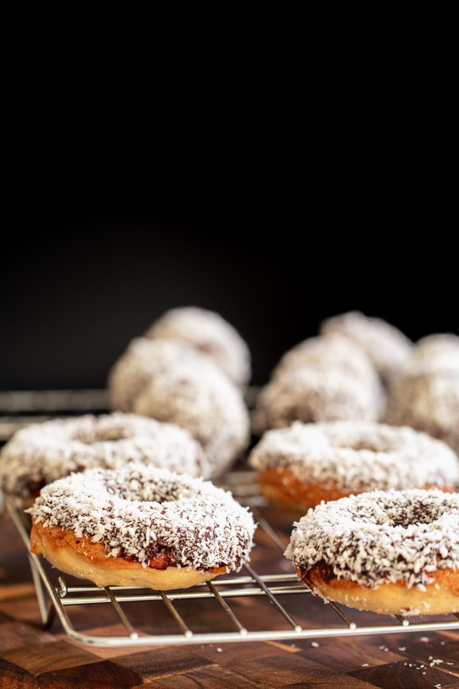 side view of vegan lamington donuts and donuts holes cooling on a cooling rack